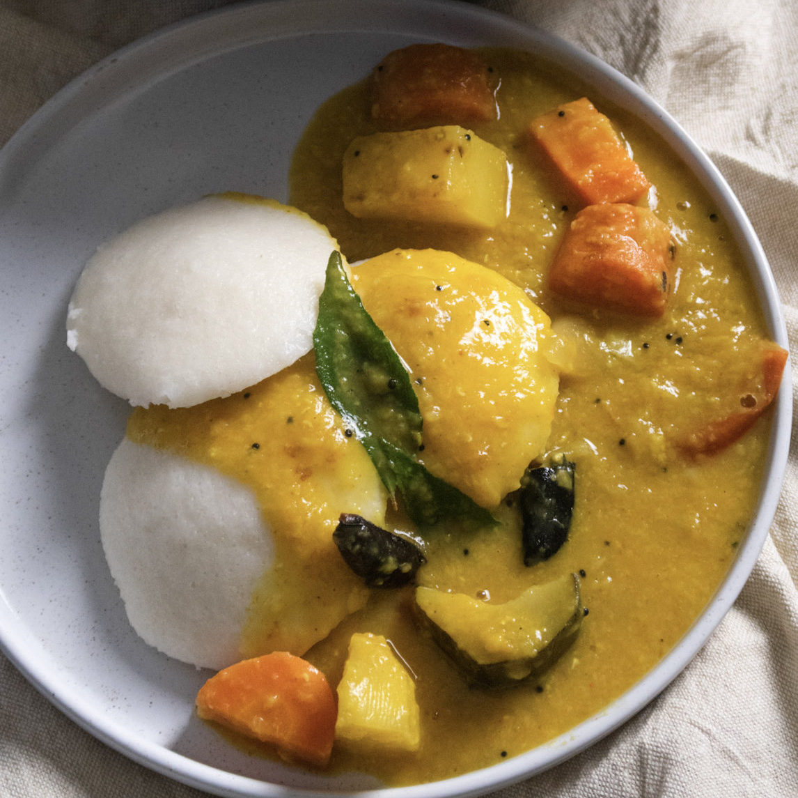 Idli served on a plate with sambar