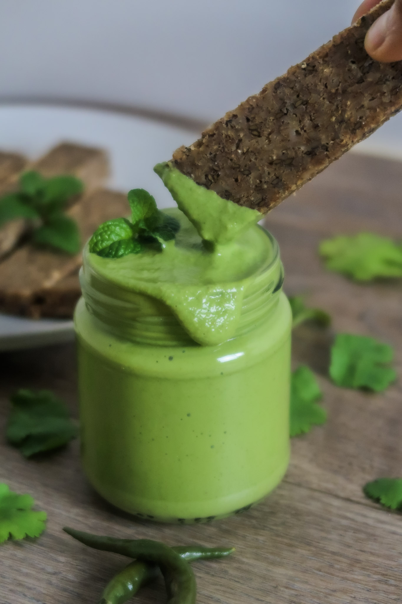 Dipping bread in mint coriander chutney served in a jar