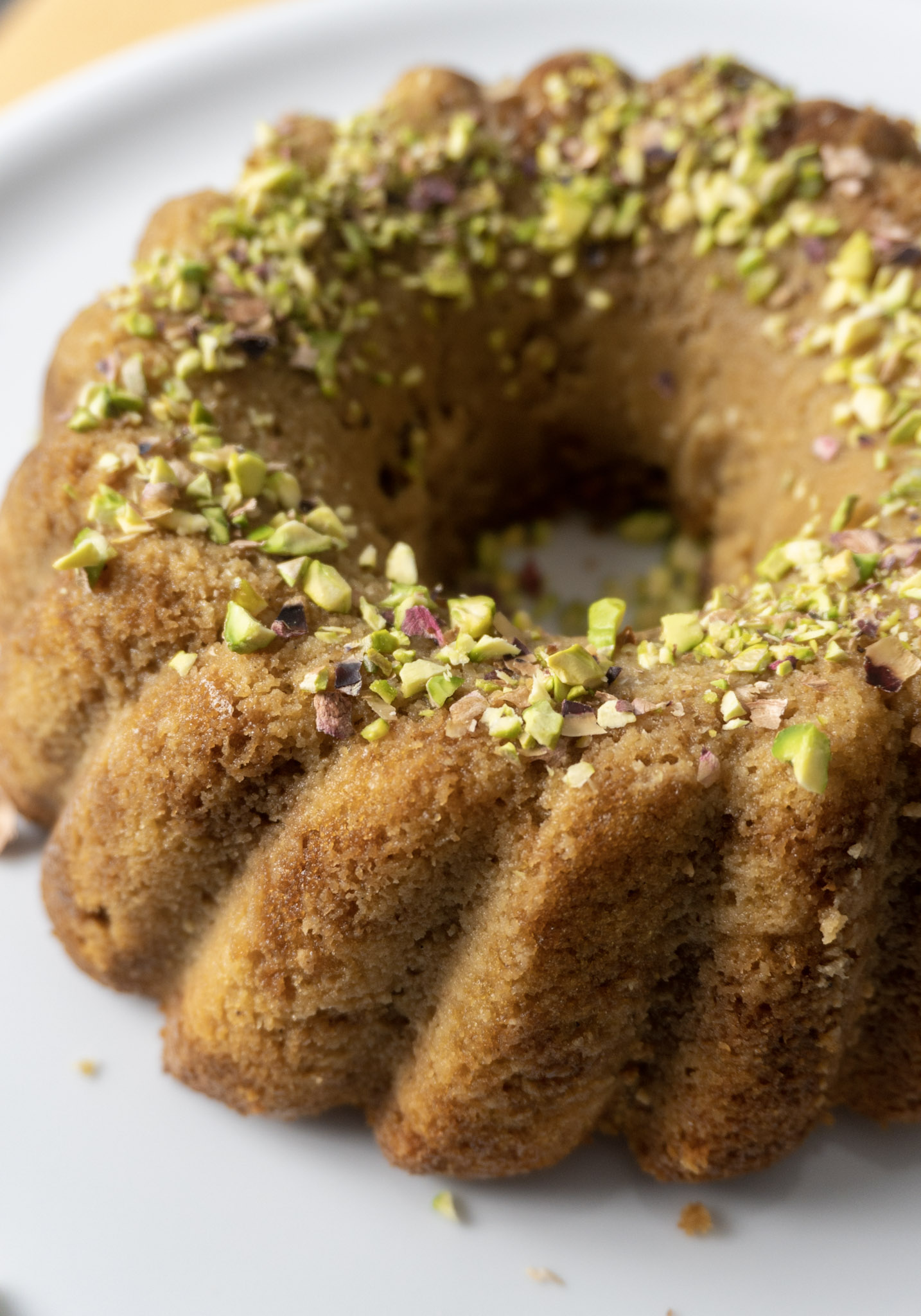 Vegan Gulab Jamun Bundt cake on a white cake stand, close up