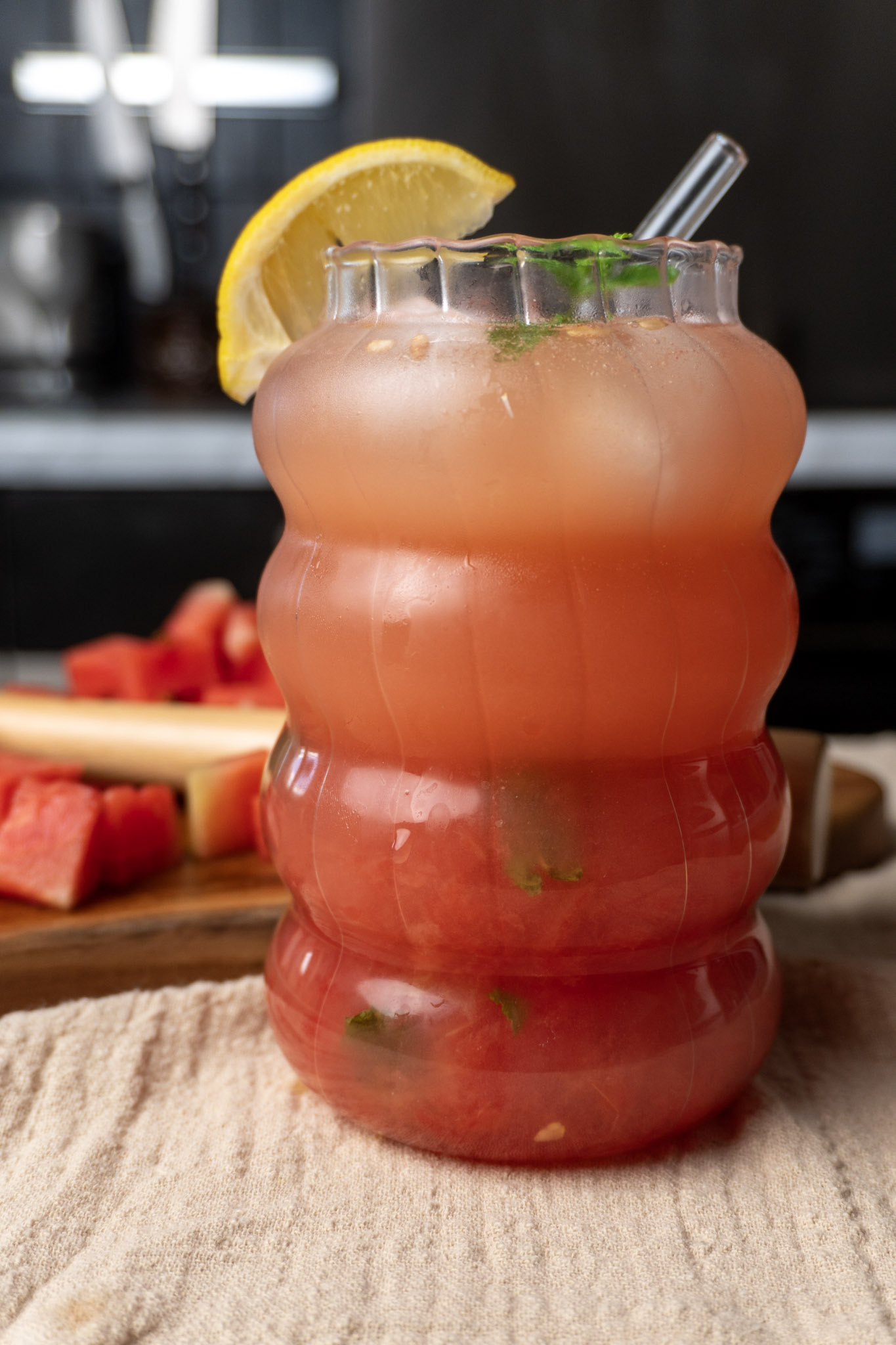 Watermelon cocktail spritzer in a tall glass topped with mint leaves