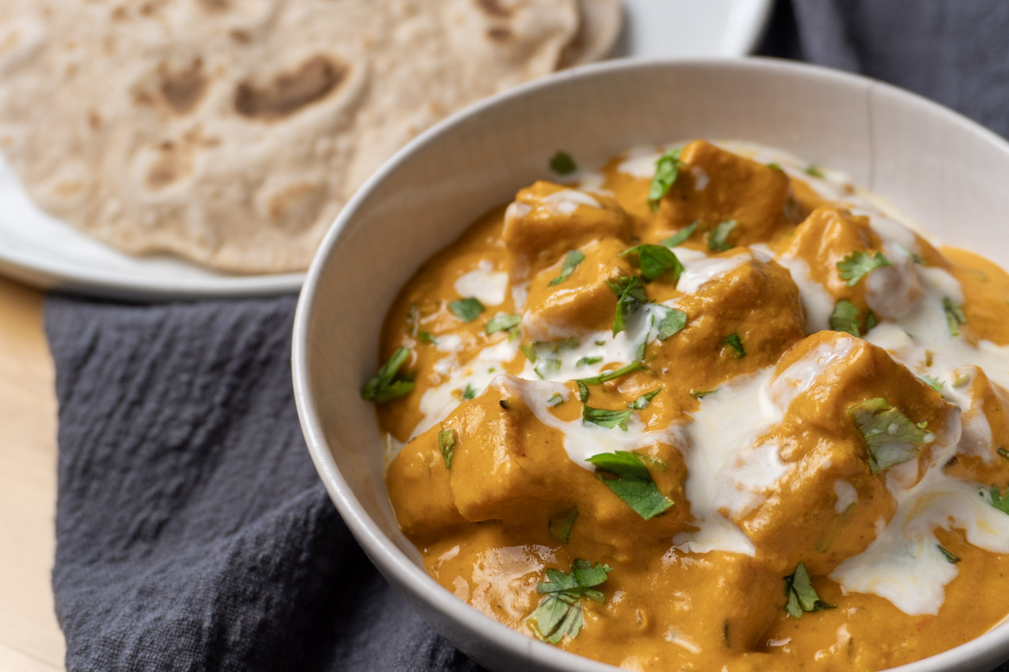 Creamy red lentil tofu masala served with a side of fresh roti