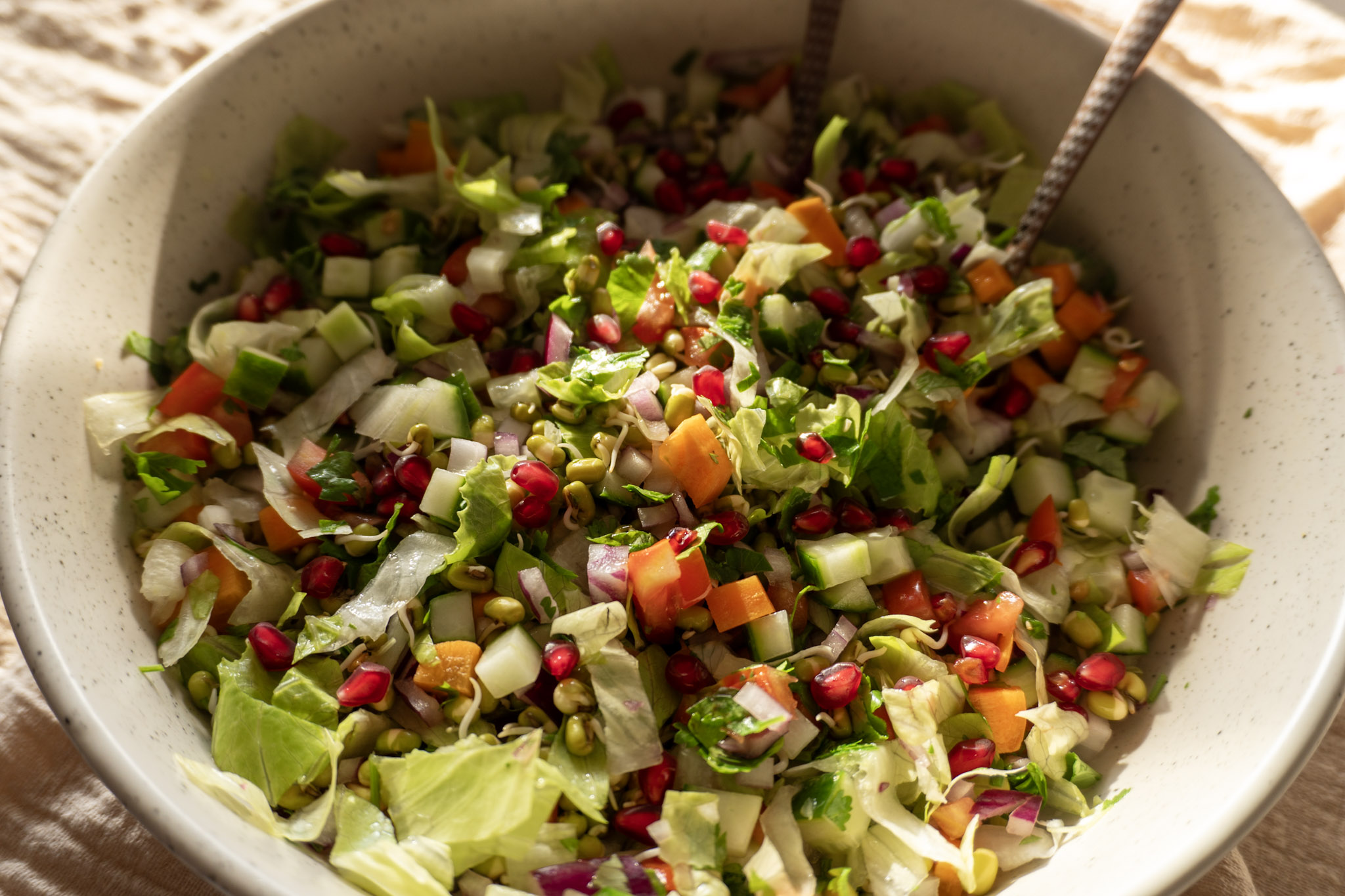 Mung bean salad in a white bowl with a fork