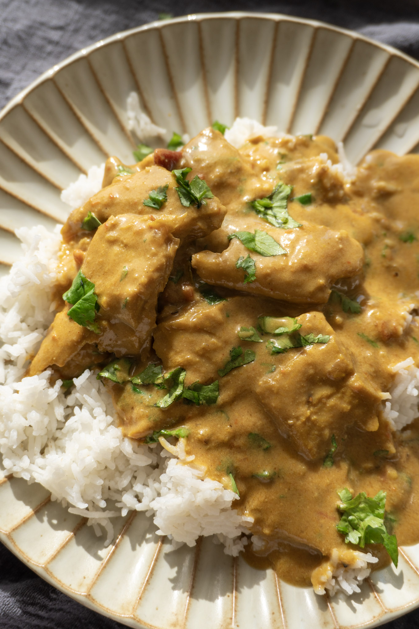 Vegan chicken curry served over rice on a white plate
