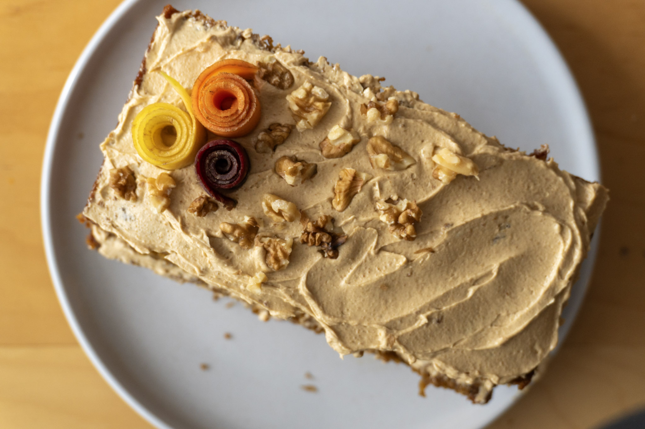 Vegan vanilla buttercream frosting on top of the carrot cake