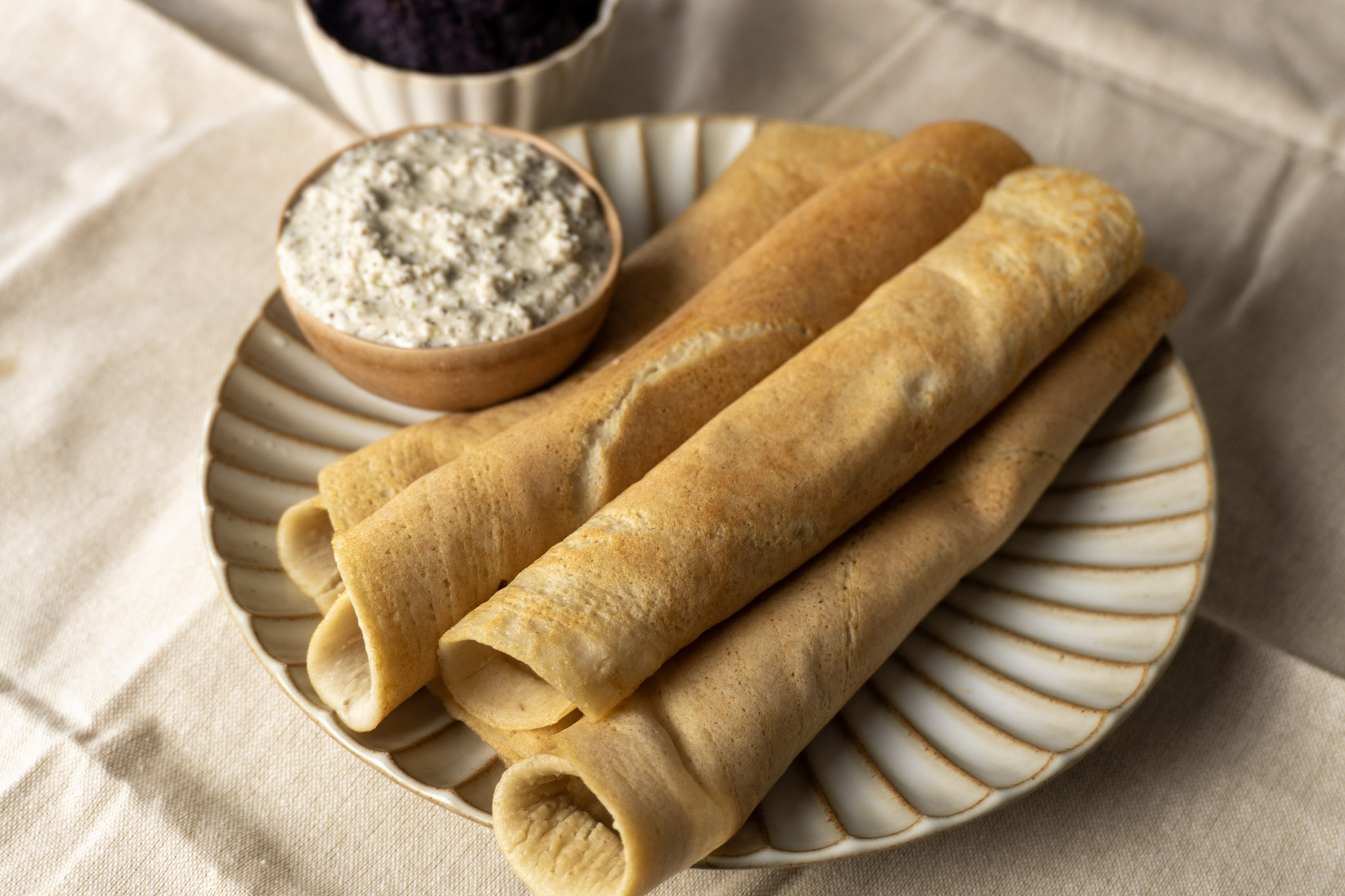 high protein quinoa crepe on a white plate served with coconut chutney
