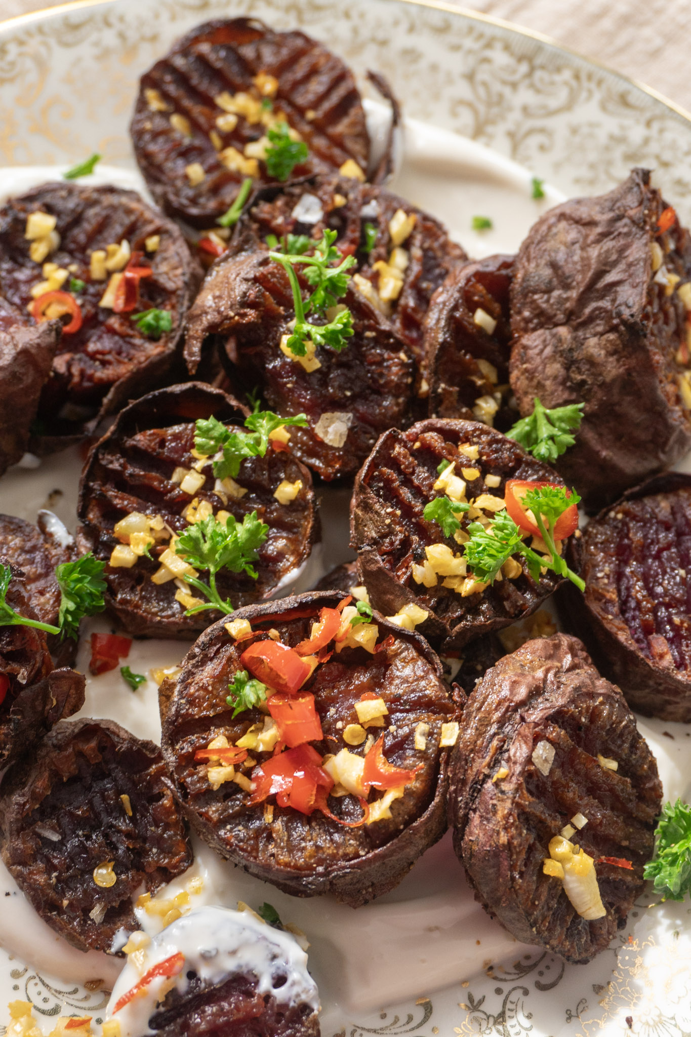 Spicy Garlic Roasted Purple Sweet Potatoes on a yogurt bed on a plate