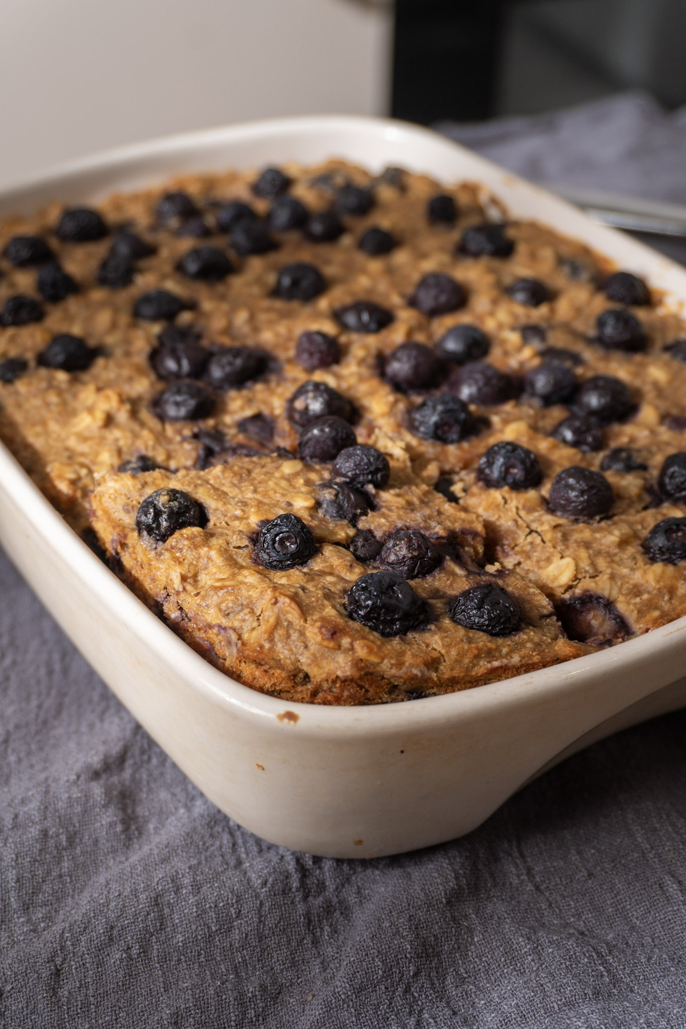 Vegan Lemon blueberry baked oats sliced in a baking dish.