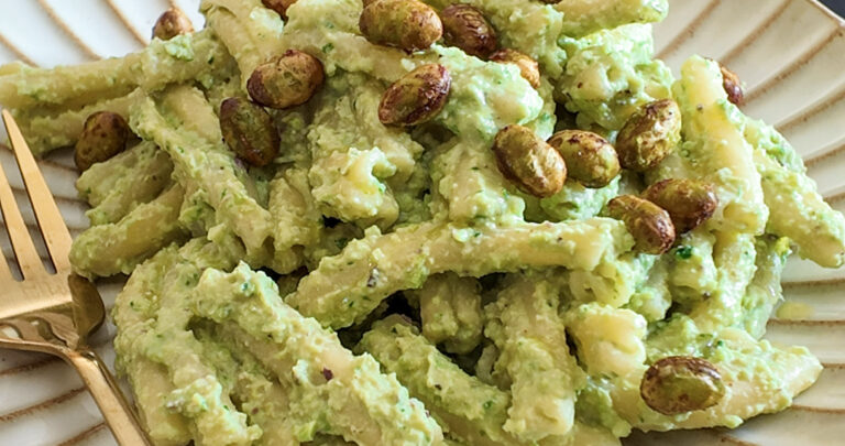 Edamame pasta on a white plate with a fork on the side, front shot