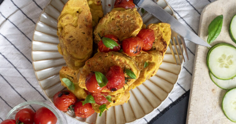top view of plated slices of savory vegan french toast topped with cherry tomatoes and mint leaves