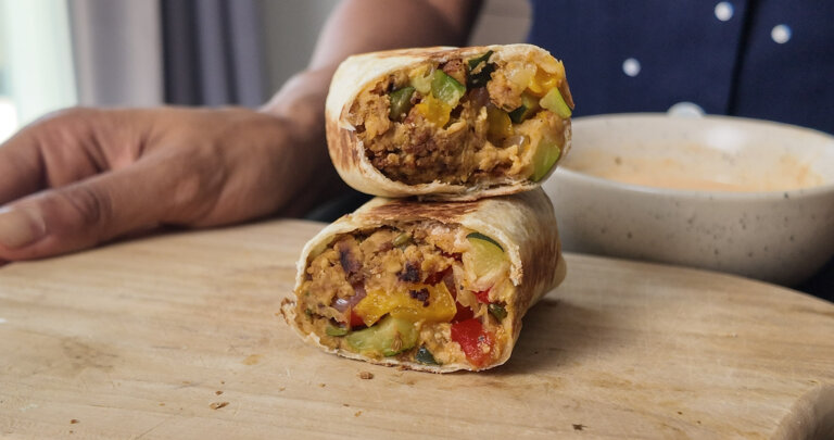 tempeh breakfast burrito sliced in two, stacked on top of each other.
